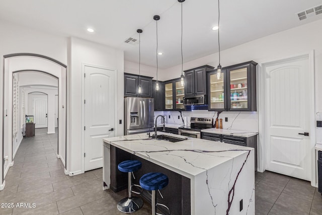 20689 W Valley View Dr, Buckeye, AZ 85396 - kitchen with appliances with stainless steel finishes, a sink, tile patterned floors, a center island with sink, and recessed lighting