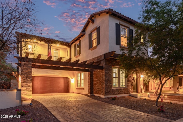 20689 W Valley View Dr, Buckeye, AZ 85396 - mediterranean / spanish-style home featuring a balcony, decorative driveway, stucco siding, a tiled roof, and a garage