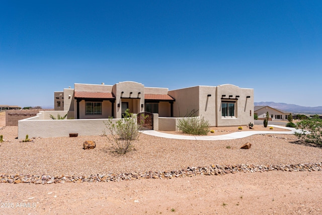 6397 E Red Oak Cir, Hereford, AZ 85615 - pueblo-style home featuring a mountain view, a fenced front yard, a tile roof, and stucco siding