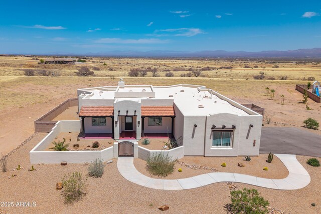 6397 E Red Oak Cir, Hereford, AZ 85615 - pueblo-style home with stucco siding, a gate, a tiled roof, a rural view, and a fenced front yard