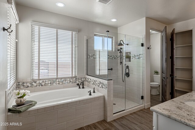 6397 E Red Oak Cir, Hereford, AZ 85615 - bathroom featuring a garden tub, vanity, visible vents, wood finished floors, and a shower stall