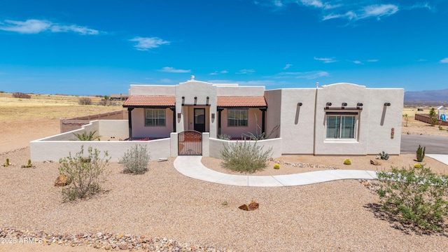 6397 E Red Oak Cir, Hereford, AZ 85615 - pueblo-style house with a gate, a fenced front yard, stucco siding, and a tiled roof