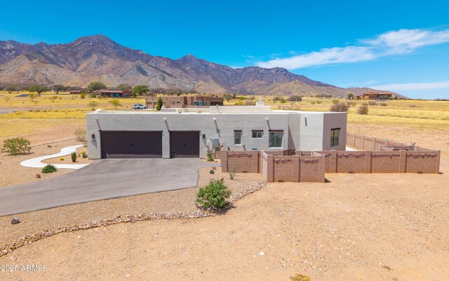 6397 E Red Oak Cir, Hereford, AZ 85615 - pueblo-style house featuring fence, stucco siding, concrete driveway, an attached garage, and a mountain view