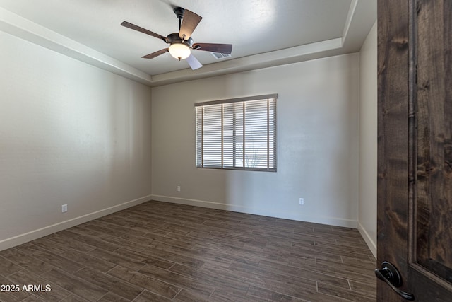 6397 E Red Oak Cir, Hereford, AZ 85615 - unfurnished room with baseboards, ceiling fan, a tray ceiling, and dark wood-style flooring