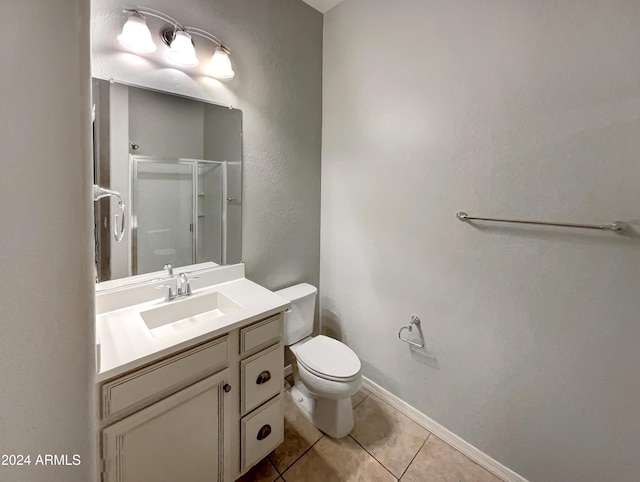 bathroom with toilet, vanity, tile patterned floors, and a shower with shower door