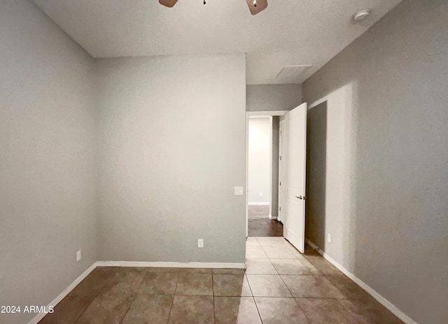 tiled spare room with ceiling fan