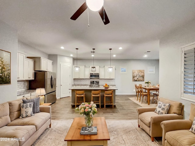 living room featuring ceiling fan and light wood-type flooring