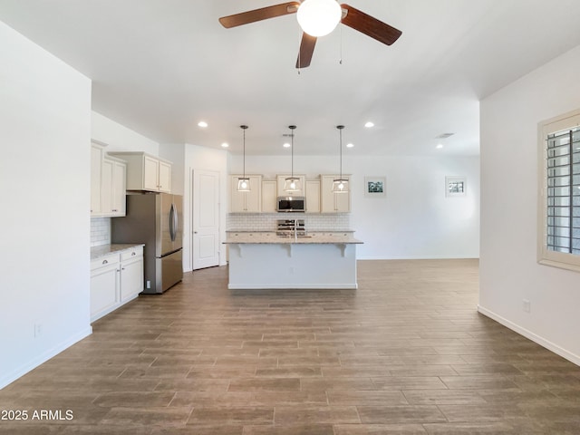 10559 E Simone Ave, Mesa, AZ 85212 - kitchen with stainless steel appliances, ceiling fan, tasteful backsplash, a kitchen breakfast bar, and recessed lighting