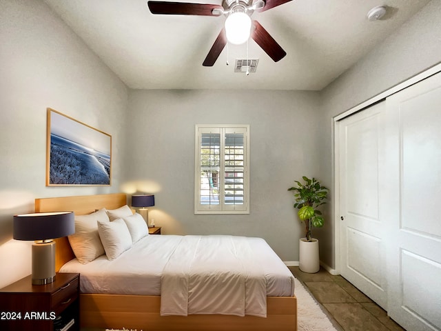 bedroom featuring ceiling fan, light tile patterned flooring, and a closet