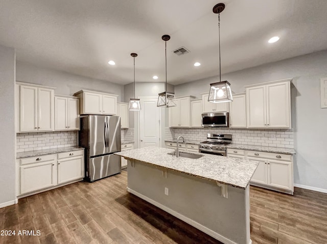 kitchen with hardwood / wood-style floors, hanging light fixtures, sink, and appliances with stainless steel finishes