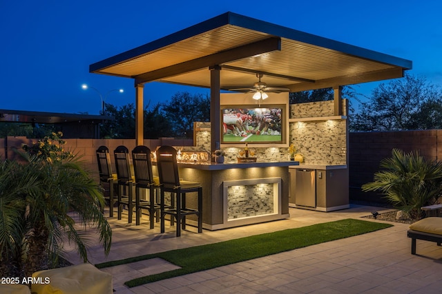 5250 S Wesley Cir, Mesa, AZ 85212 - patio at night featuring a fenced backyard, exterior bar, a patio, and a ceiling fan