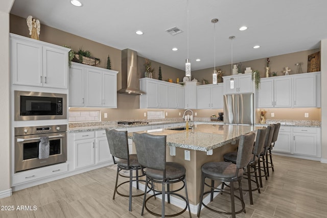 5250 S Wesley Cir, Mesa, AZ 85212 - kitchen featuring appliances with stainless steel finishes, wall chimney exhaust hood, a sink, white cabinetry, and recessed lighting