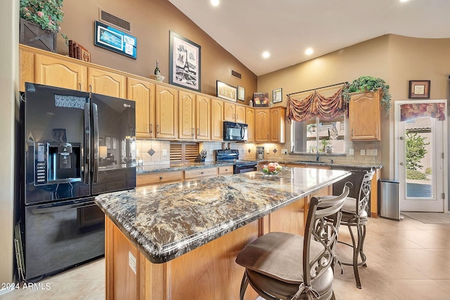 kitchen with backsplash, black appliances, a center island, and sink