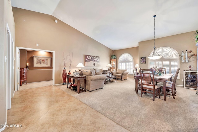 living room with light colored carpet and high vaulted ceiling