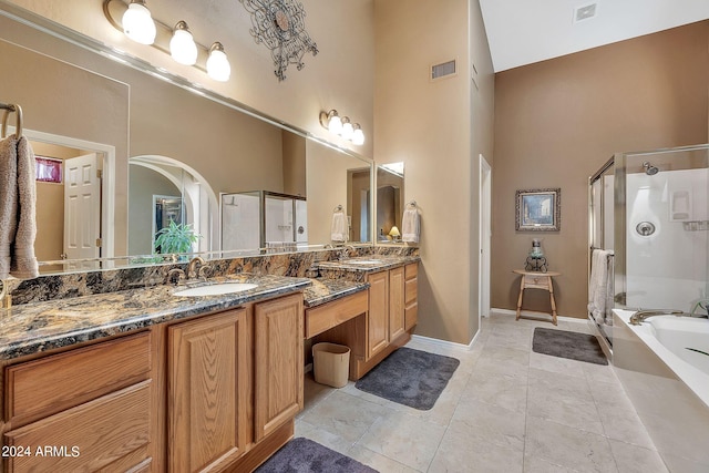 bathroom featuring plus walk in shower, a high ceiling, tile patterned flooring, and vanity