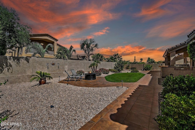 yard at dusk featuring an outdoor fire pit and a patio area