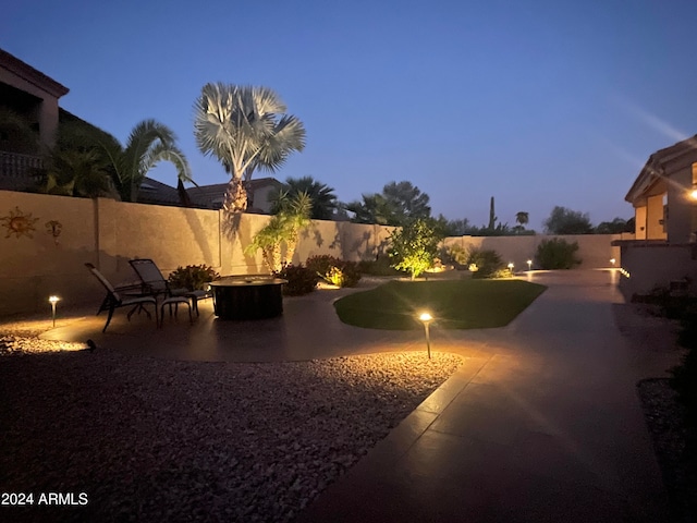 yard at dusk with a patio area and a fire pit