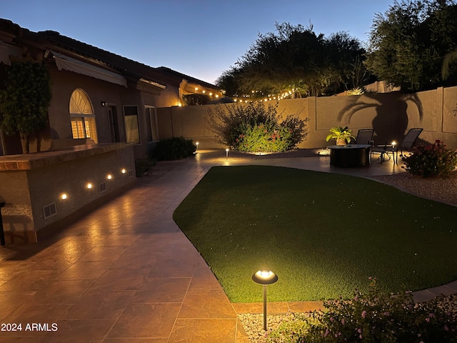 pool at dusk with a patio area