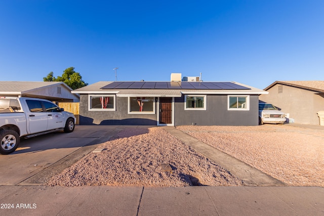 ranch-style home featuring solar panels