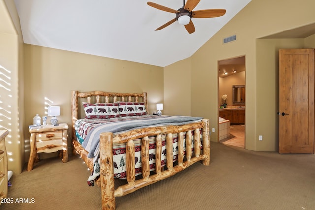 bedroom with ensuite bathroom, ceiling fan, carpet floors, and vaulted ceiling