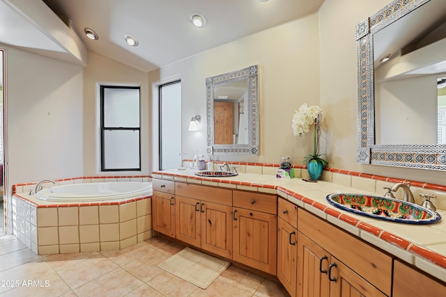 bathroom featuring tile patterned flooring, vanity, tiled bath, and vaulted ceiling