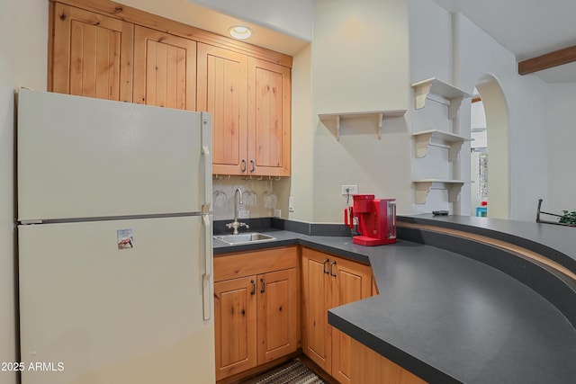 kitchen with white refrigerator, tasteful backsplash, and sink