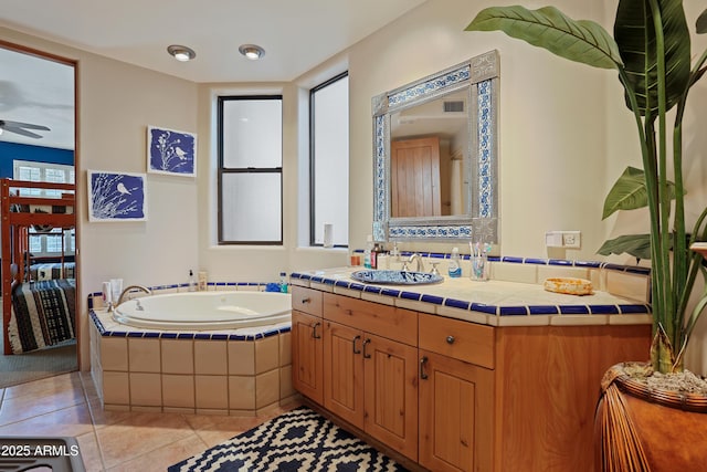 bathroom featuring ceiling fan, tile patterned flooring, vanity, and a relaxing tiled tub