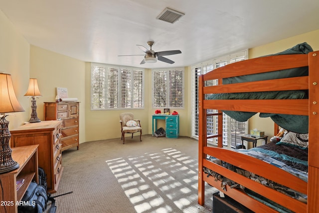 bedroom with ceiling fan, light carpet, and multiple windows