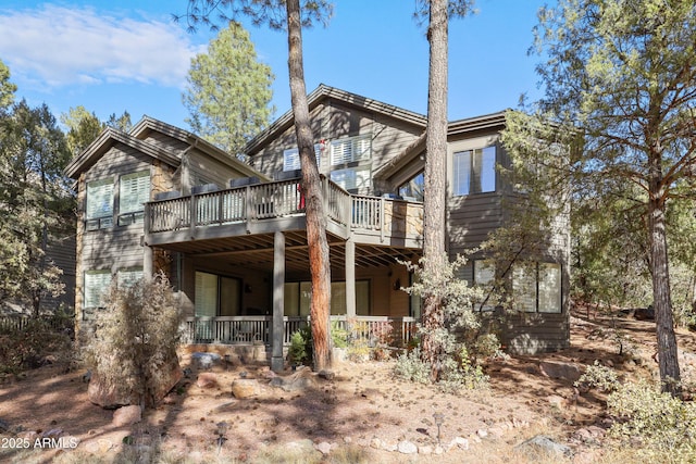 rear view of house featuring a wooden deck