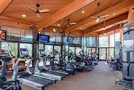 gym with ceiling fan, wood ceiling, and lofted ceiling