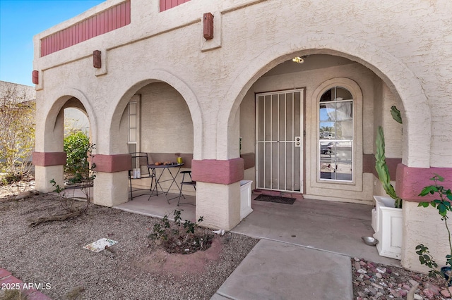 doorway to property featuring stucco siding