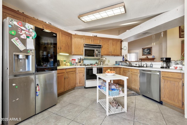 kitchen featuring light tile patterned flooring, appliances with stainless steel finishes, light countertops, and a sink