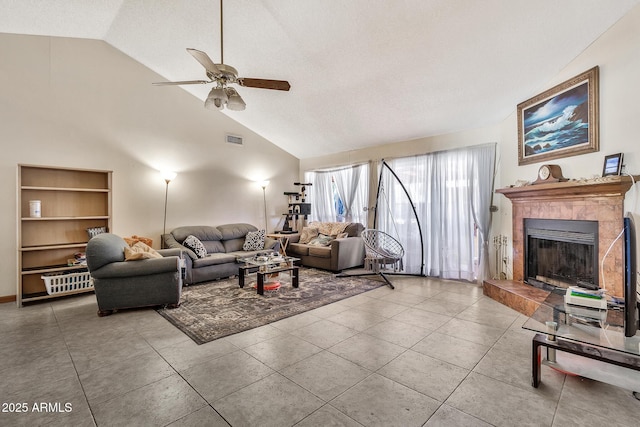 living room with visible vents, high vaulted ceiling, a fireplace, ceiling fan, and tile patterned floors