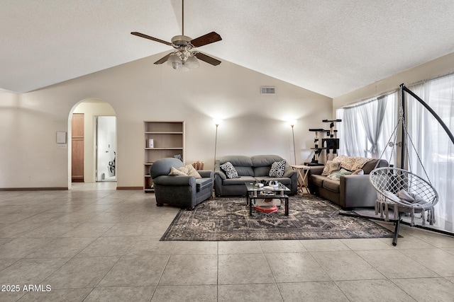 tiled living area with visible vents, baseboards, built in features, arched walkways, and a textured ceiling