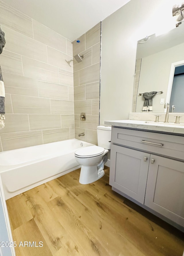 full bath with vanity, toilet, wood finished floors, and shower / bathtub combination