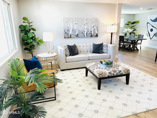 living room with a healthy amount of sunlight, light wood-style floors, and baseboards