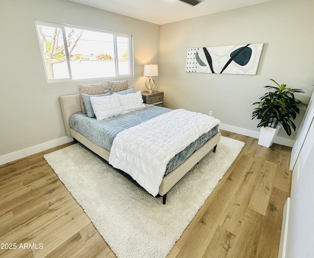 bedroom featuring baseboards and light wood-style floors