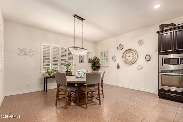 dining room with an inviting chandelier and light tile patterned floors