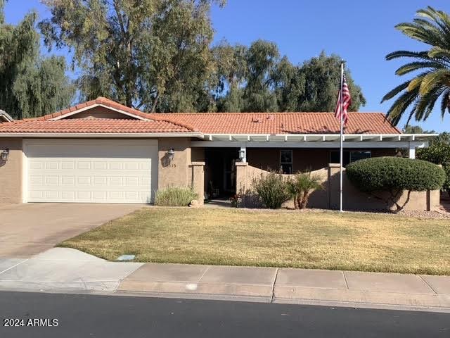 ranch-style home featuring a garage and a front yard