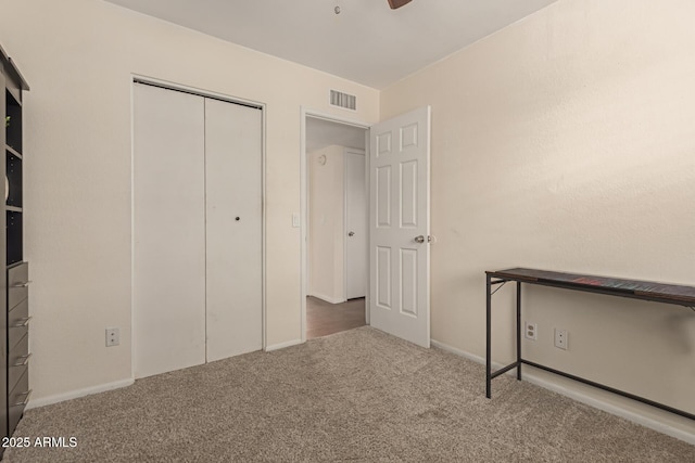 unfurnished bedroom with a closet, carpet flooring, and visible vents