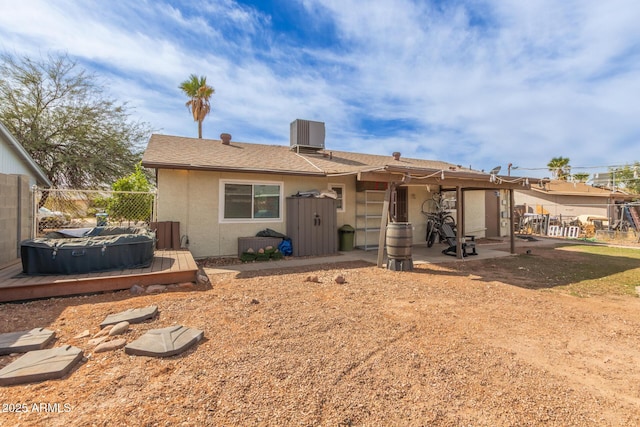 rear view of property featuring stucco siding, a patio, central AC, and fence