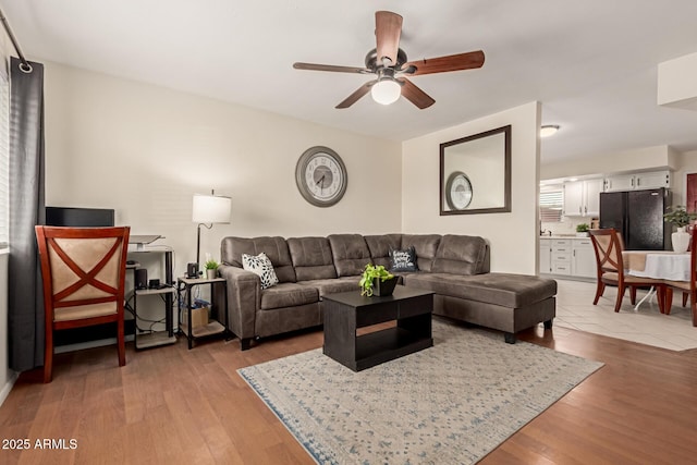 living room with light wood-style flooring and ceiling fan