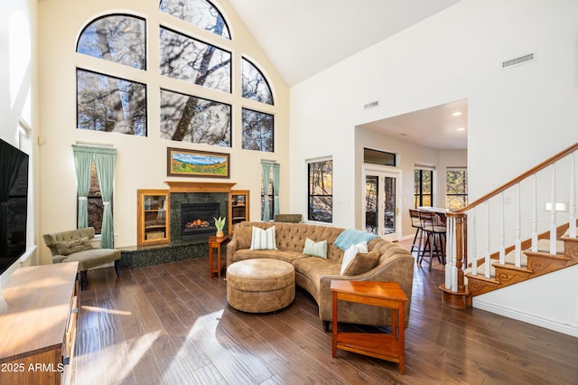 living room with dark wood-type flooring, a fireplace, and high vaulted ceiling