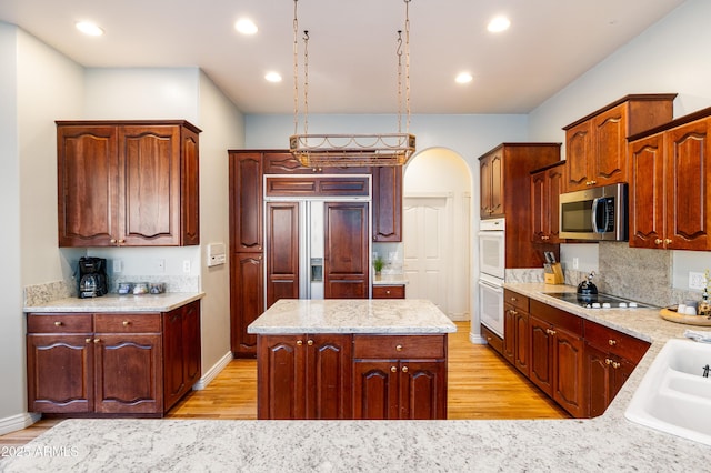 kitchen featuring paneled refrigerator, sink, light hardwood / wood-style floors, and a center island