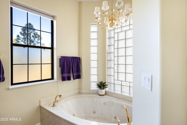 bathroom with a tub and a chandelier