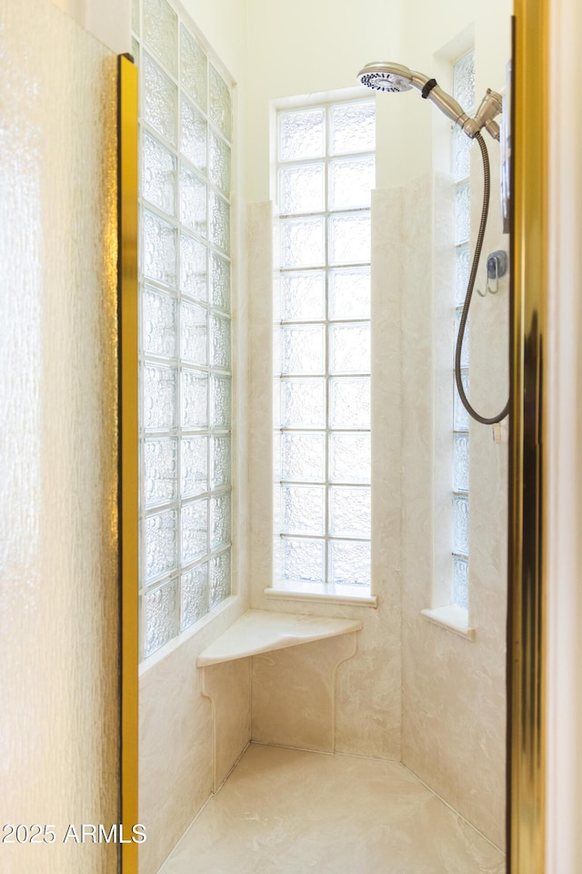 bathroom with plenty of natural light and a tile shower