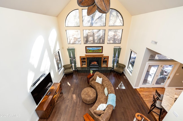 living room with a high end fireplace, dark hardwood / wood-style floors, high vaulted ceiling, and a wealth of natural light