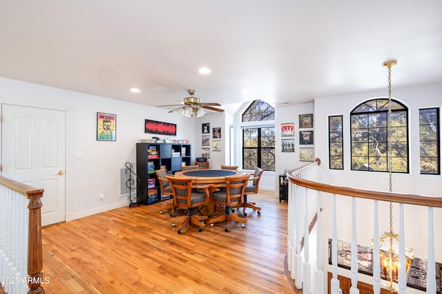 dining space featuring ceiling fan with notable chandelier and light hardwood / wood-style floors