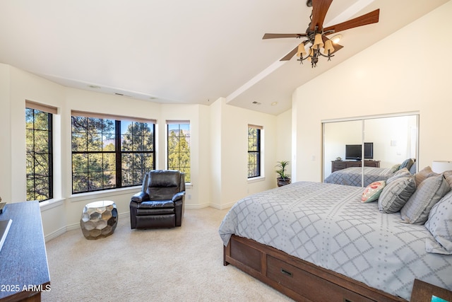 carpeted bedroom featuring ceiling fan, vaulted ceiling, and a closet