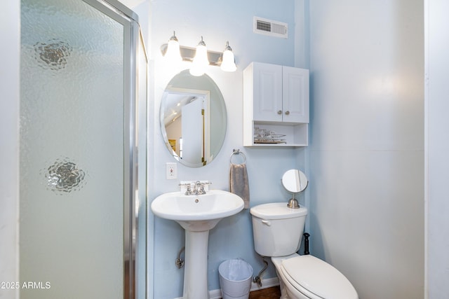 bathroom with toilet, an enclosed shower, and sink